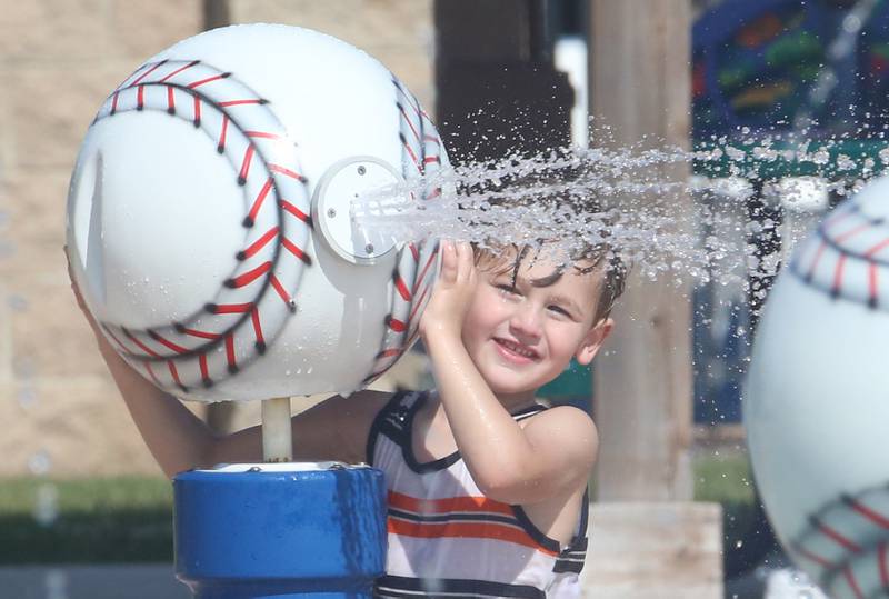 Cain Cauley of Ottawa sprays water out of a baseball at the splash pad on Thursday, July 27, 2023 at Washington Park in Peru.
