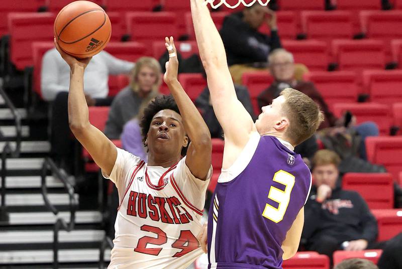 Northern Illinois Huskies guard Darweshi Hunter tries to get a shot up over Albany Great Danes forward Trey Hutcheson during their game Tuesday, Dec. 20, 2022, in the Convocation Center at NIU in DeKalb.