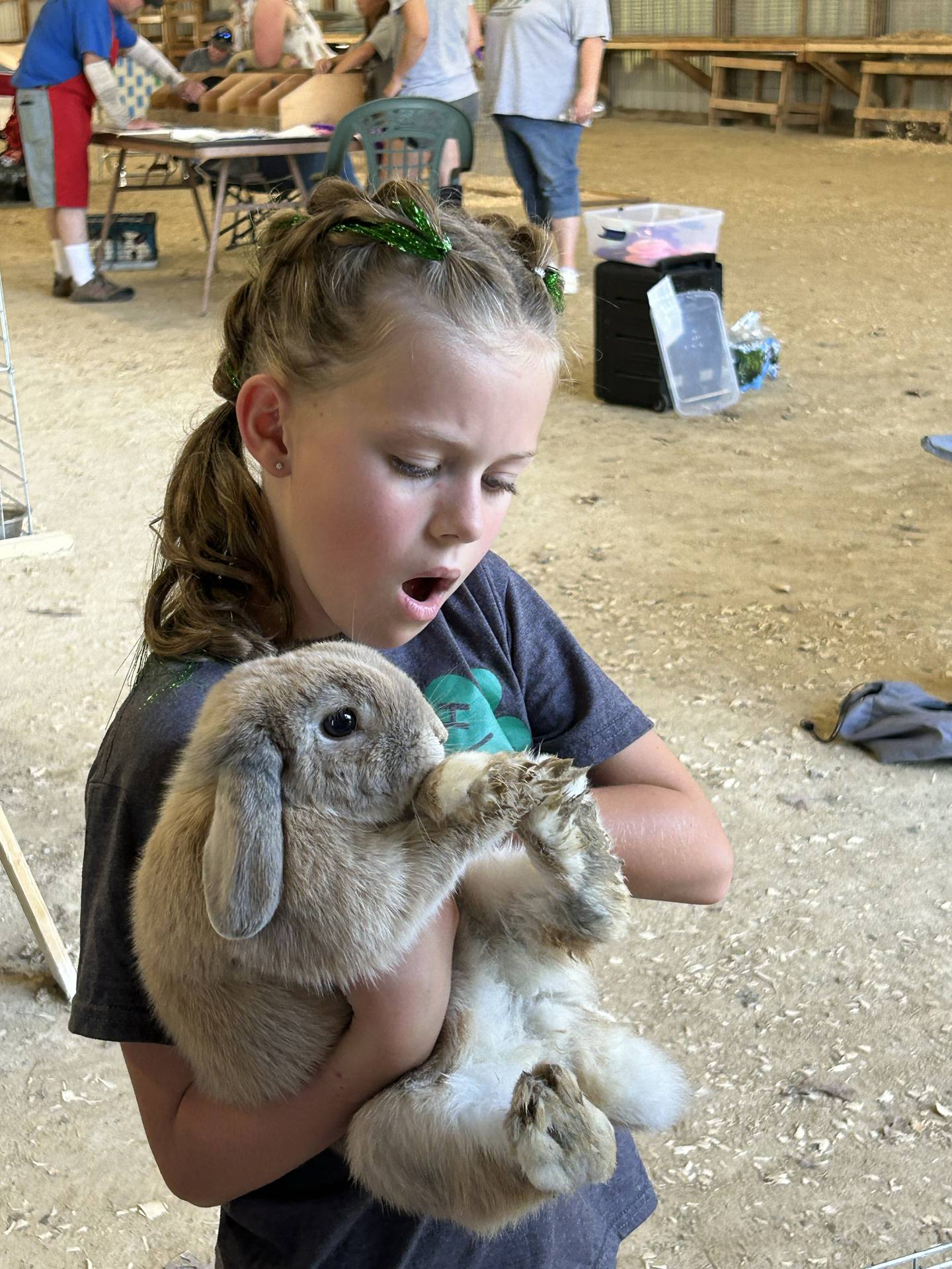 Tinsley Downie, 10, of Rock Falls, reacts to the mess her brother's rabbit "Potato" made in his cage while waiting to be judged at the Whiteside County 4H Fair in Morrison on Friday, July 12, 2024. Tinsley was showing Potato for her little brother Cole, 7.