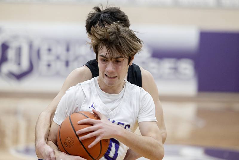 Dixon’s Mason Weigle holds onto a rebound Saturday, Jan. 7, 2023 in a game against McHenry.