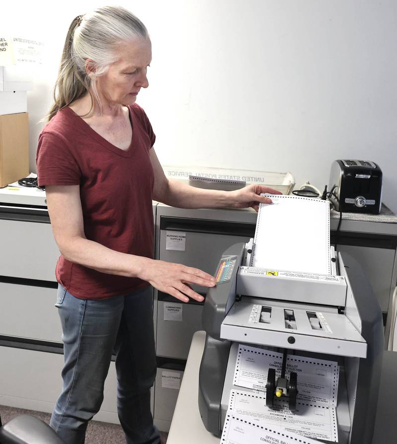 Election judge Janis Samet folds vote-by-mail ballots so they can be inserted into envelopes Wednesday, Feb. 22, 2023, in the DeKalb County Administration Building in Sycamore.