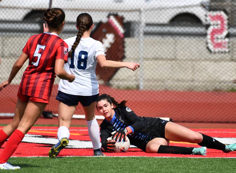 Hinsdale Central goalkeeper Emeline McClenahan (bottom) makes a save during a match against Oswego East on March, 30, 2024 at Hinsdale Central High School in Hinsdale.