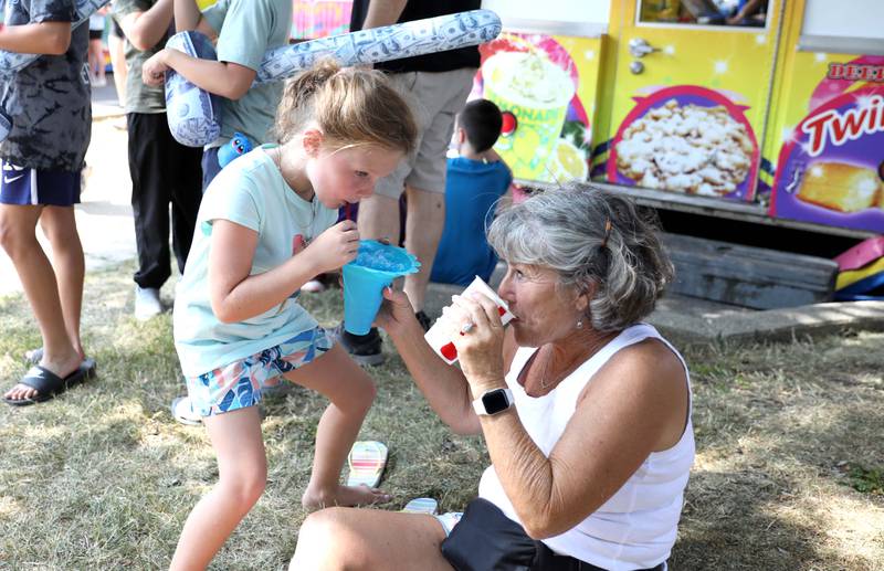 Peggy Young of Geneva (right) cools off with granddaughter Sophie Young, 6, who is visiting from Florida, during the first day of the 2023 Swedish Days Festival in Geneva on Wednesday, June 21, 2023.