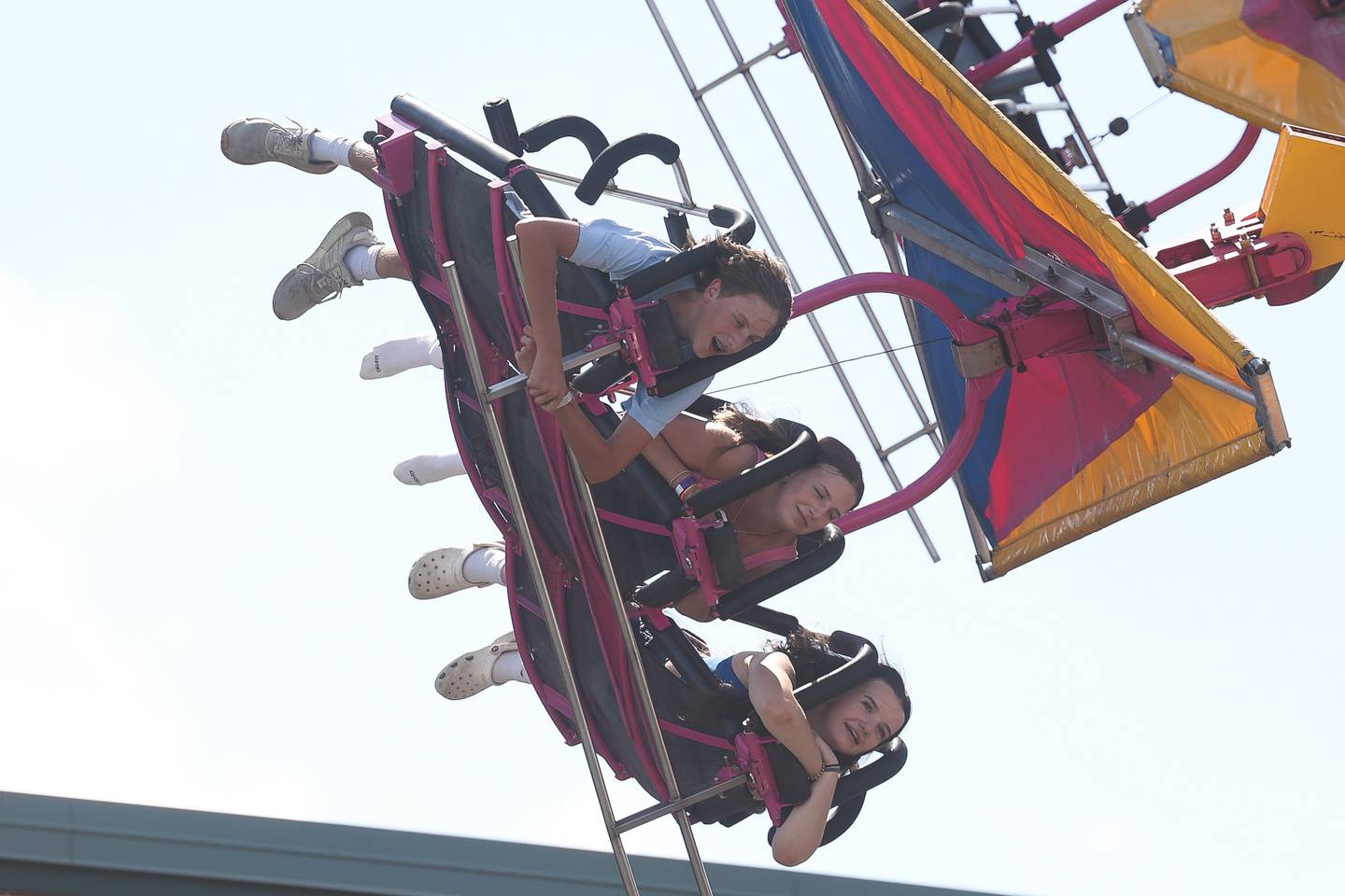 A group of teens ride the Cliff Hanger at Plainfield Fest on Saturday June 29, 2024.