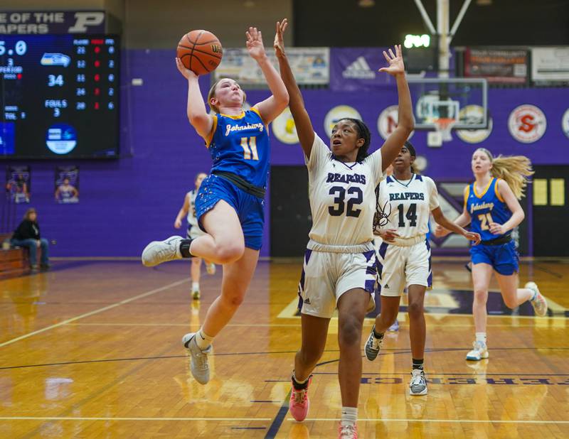 Johnsburg's Lauren Foszcz (11) drives to the hoop against Plano's Nylah Mathews (32) during a basketball game at Plano High School on Tuesday, Jan 30, 2024.