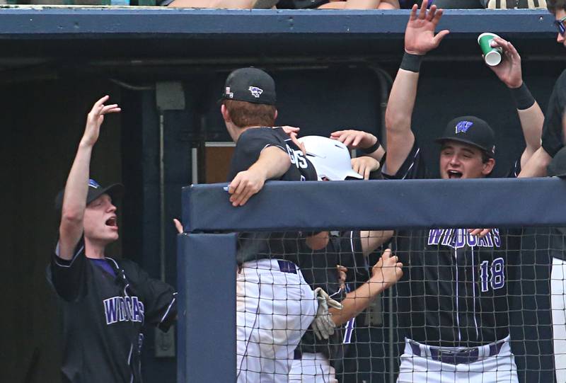 Wilmington players congratulate their teammate Ryan Kettman after scoring the teams first run during the Class 2A third place game on Saturday, June 1, 2024 at Dozer Park in Peoria.