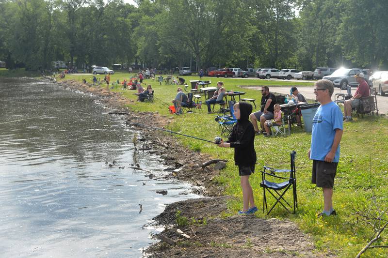 Lincoln Ford-Skadberg, 10, of Hillsdale, casts his line into the Rock River as his dad, Andy, watches during the 18th annual Dick Brown Fishing Derby at Prophetstown State Park on Saturday, June 15, 2024.
